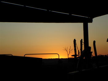 Silhouette construction site against sky during sunset