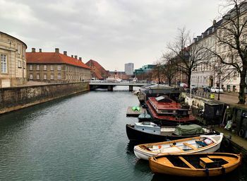 Boats in canal amidst buildings in city