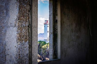 Old building by sea against sky