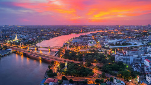 High angle view of illuminated city buildings during sunset