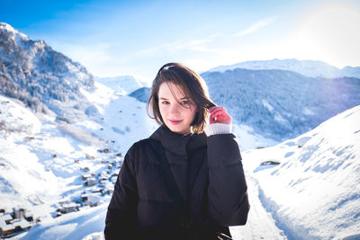 Portrait of woman standing on snowcapped mountains during winter