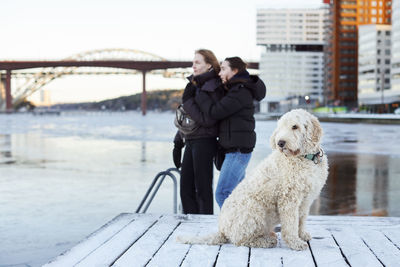 Young women and dog standing at river