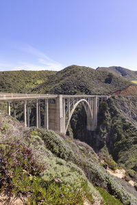 Bridge over mountains against clear sky