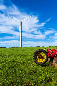 Windmill on field against sky