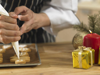 Midsection of chef preparing gingerbread cookies on table