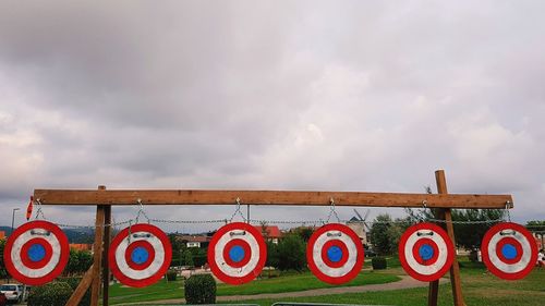 Multi colored sign on grass against sky