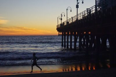 Silhouette of people on beach at sunset