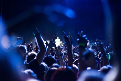 Audience with arms raised at music concert