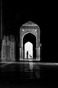 Silhouette woman walking in corridor of historic building