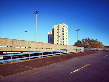 Empty road against clear blue sky