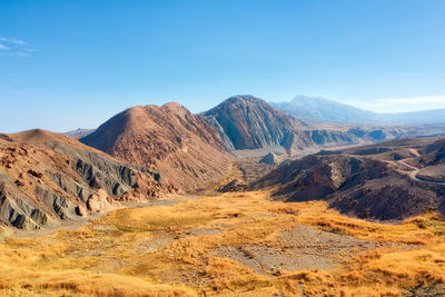 Scenic view of rocky mountains against blue sky