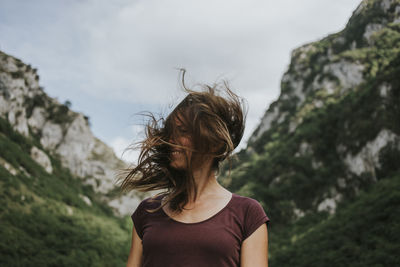 Rear view of woman standing against mountain