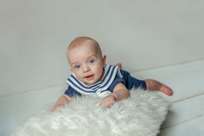 Portrait of cute baby boy lying on floor at home