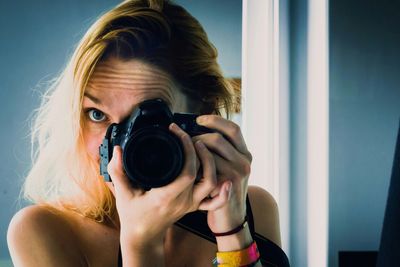 Portrait of woman photographing at home