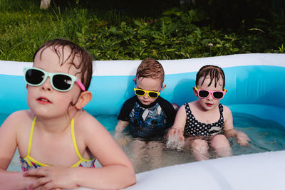 Wet serious children in the pool in sunglasses. focus on children in the background. 