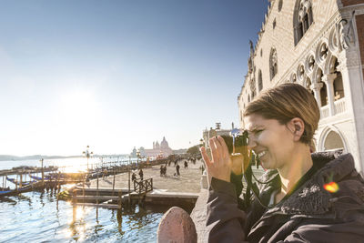 Woman photographing in city