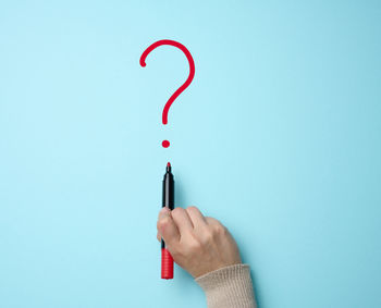 Hand drawn question mark with a red marker on a blue background. search for an answer, find the tru