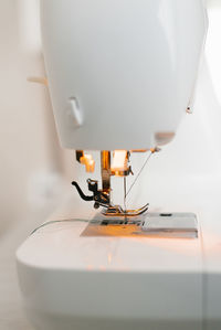 Close-up of sewing machine parts, needle and thread