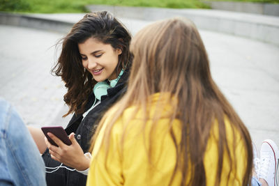 Young woman using mobile phone while standing on camera