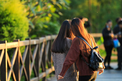 Rear view of woman standing against railing