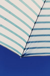 Low angle view of umbrella against blue sky