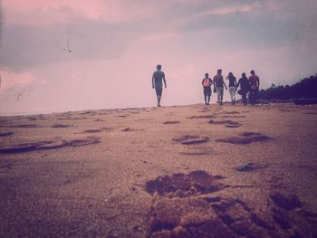 Rear view of people walking on beach