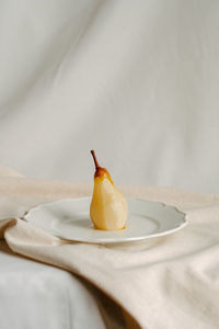 Photo of a pear on a plate healthy wellbeing eye level view photography natural textures lifestyle 