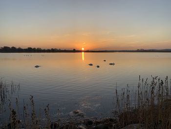 Scenic view of lake against sky during sunset