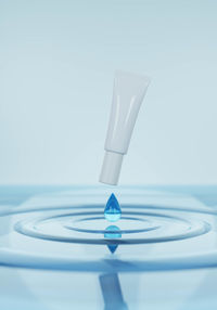 Close-up of glass on table against white background