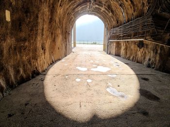 Empty road amidst walls against sky