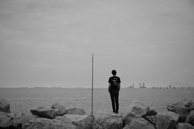 Rear view of man standing on beach