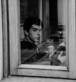 Portrait of man looking through window