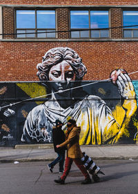 Full length of woman with graffiti on wall