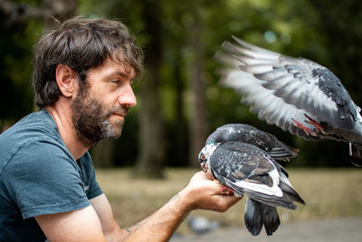 Side view of man feeding bird