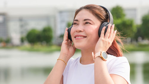 Portrait of a smiling young woman using smart phone