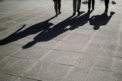 Low section of people standing on tiled floor