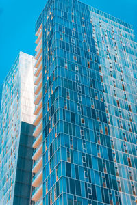 Low angle view of modern glass building against sky