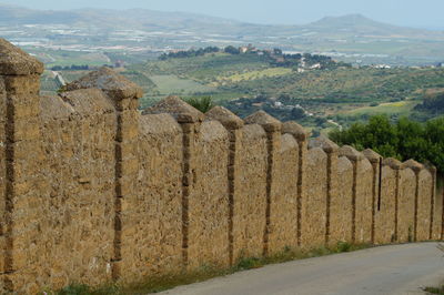 Scenic view of field by mountains against sky