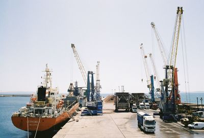 Ship moored at harbor against clear sky during sunny day