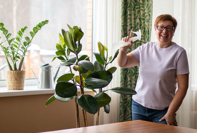 Portrait of woman holding potted plant