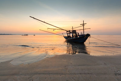 Scenic view of boat in sea at sunset