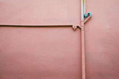 Water pipes on pink wall