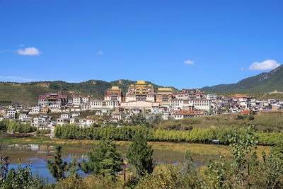 Buildings in town against blue sky