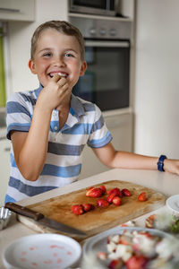 Portrait of smiling boy eating fruit