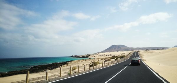 Road by sea against sky