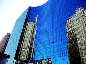 Low angle view of office building against blue sky