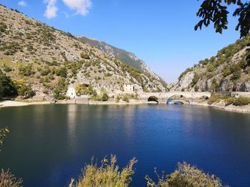 Scenic view of lake by trees against blue sky