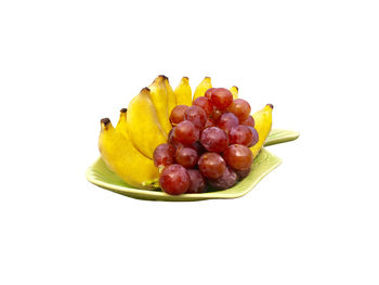 Close-up of fruits in plate against white background