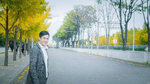 Portrait of young man standing on road