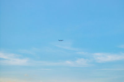 Low angle view of airplane flying against clear blue sky